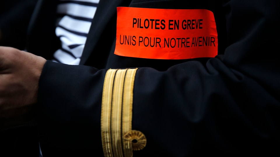Arm eines Piloten in Uniform mit Streik-Spruch.
