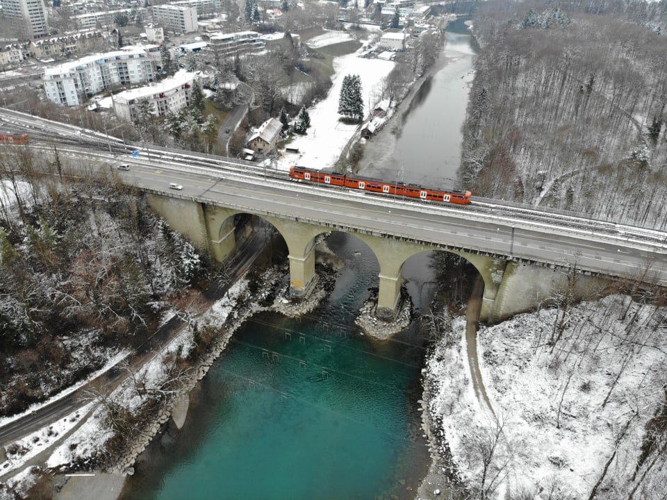 Ein Zug, der über eine Brücke über die Aare fährt aus der Vogelperspektive.