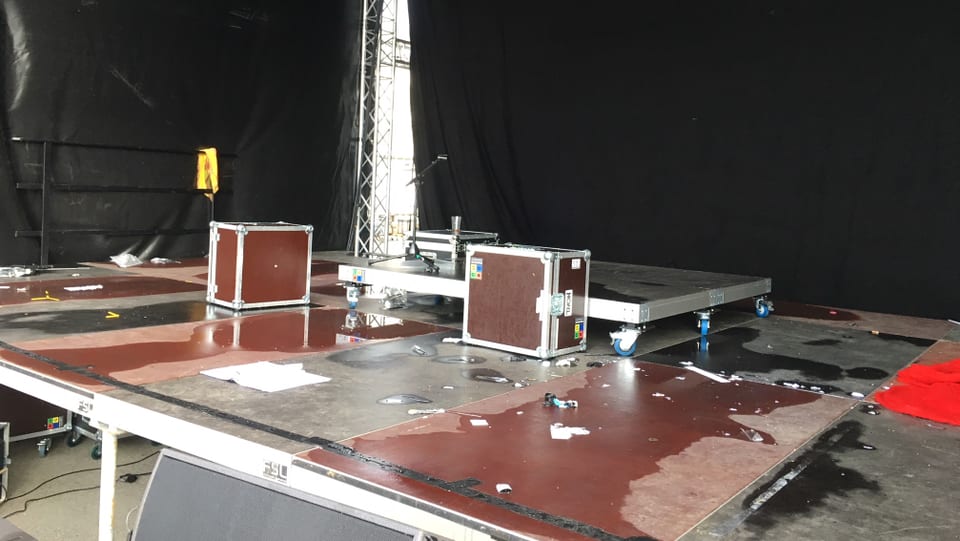 Bühne mit diversen Boxen und Wasser auf dem Boden.