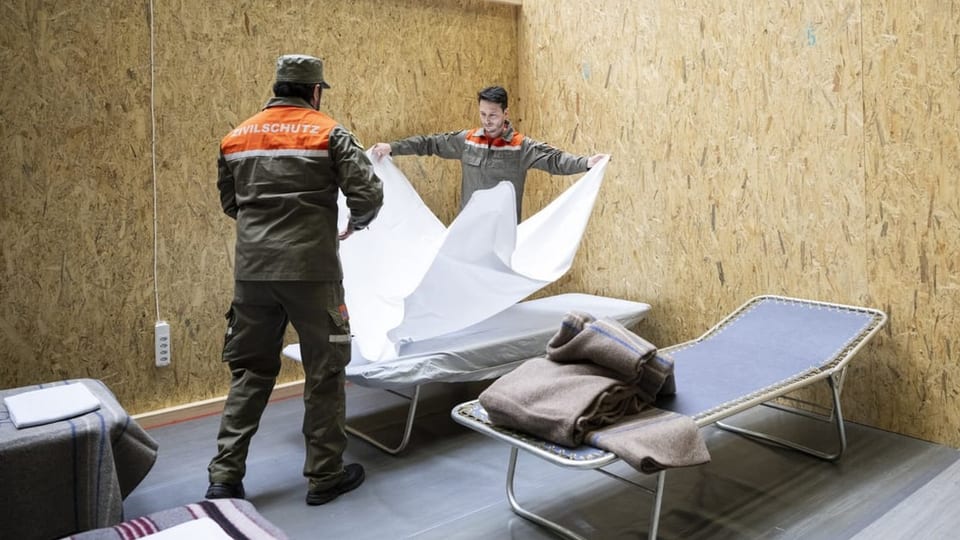 Zivilschützer helfen beim Aufbau von Betten in der Saalsporthalle in Zürich für die Unterbringung von Geflüchteten.