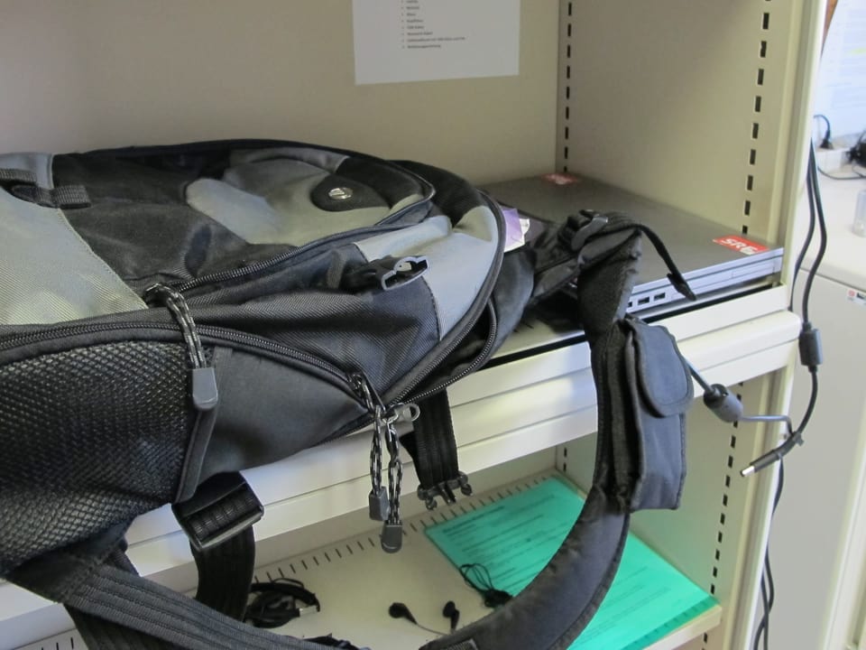 Rucksack mit Laptop in einem Bücherregal