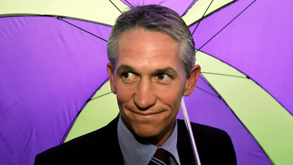 Gary Lineker unter gelb-violettem Regenschirm