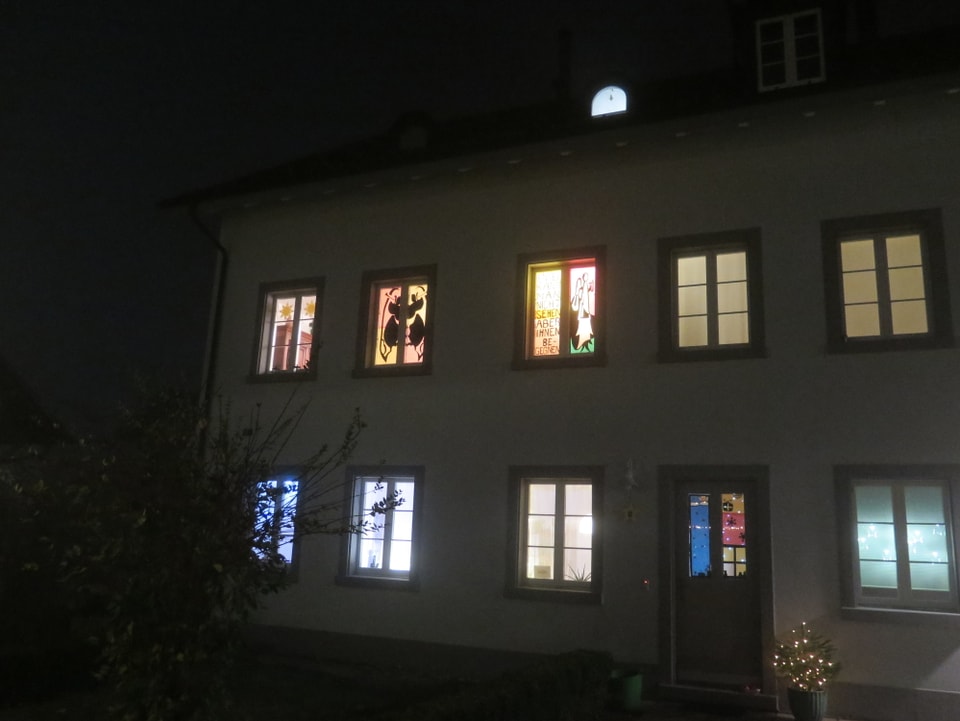 Haus mit leuchtenden Fenstern.