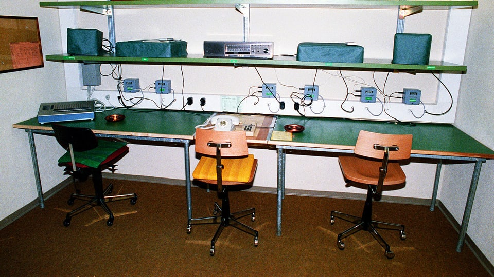Arbeitsraum in einer unterirdischen Bunkeranlage der Geheimarmee P-26 bei Gstaad: Stühle, Telefone und ein grüner Tisch.