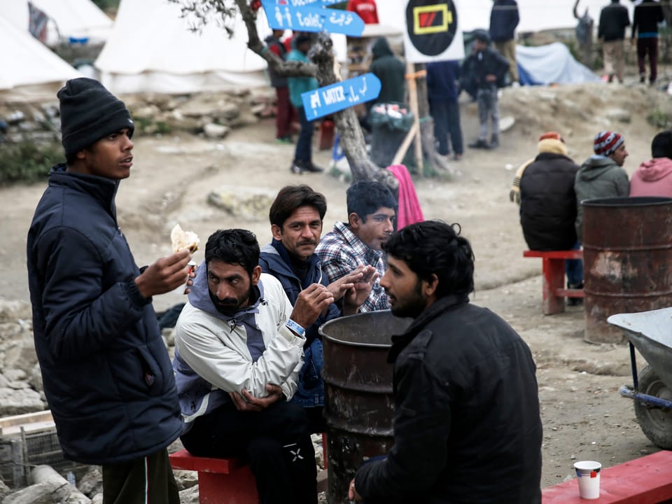 Menschen aus Afghanistan wärmen sich an einem Feuer auf Lesbos.(reuters)