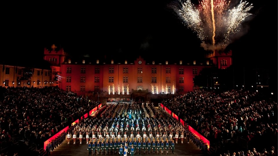 Musikformation, im Hintergrund Feuerwerk 