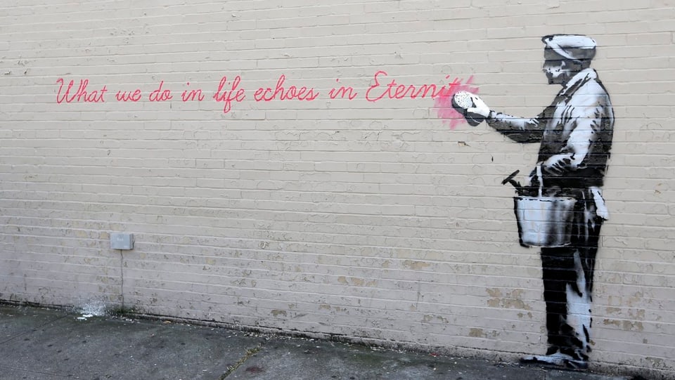 Gesprayter Mann putzt selber weg, was auf die Wand gesprayt ist: «What we do in life echoes in eternity.»