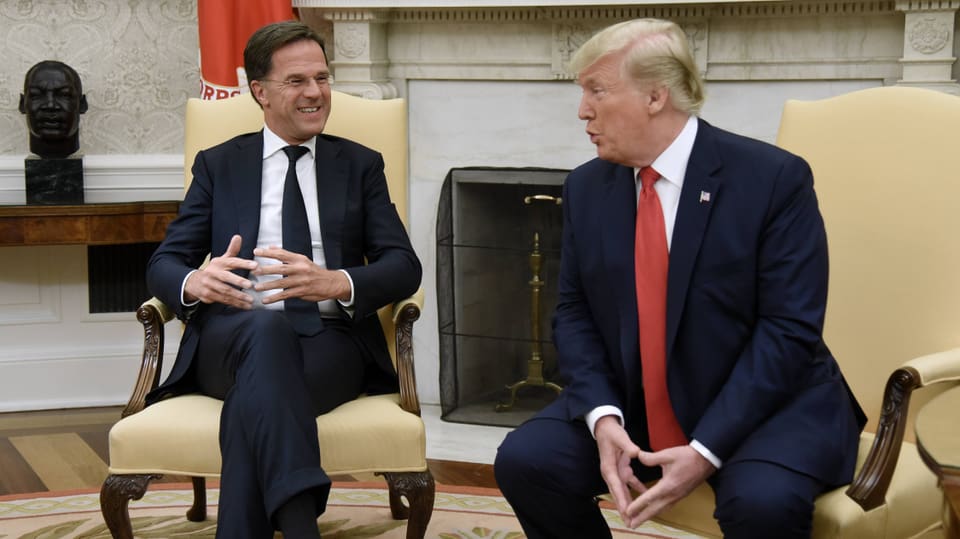 Rutte und Trump sitzen nebeneinander.
