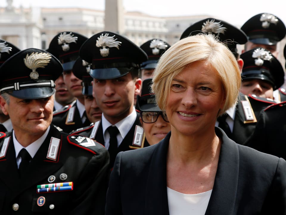 Roberta Pinotti lächelt, hinter ihr stehen Carabinieri in Gardeuniform.