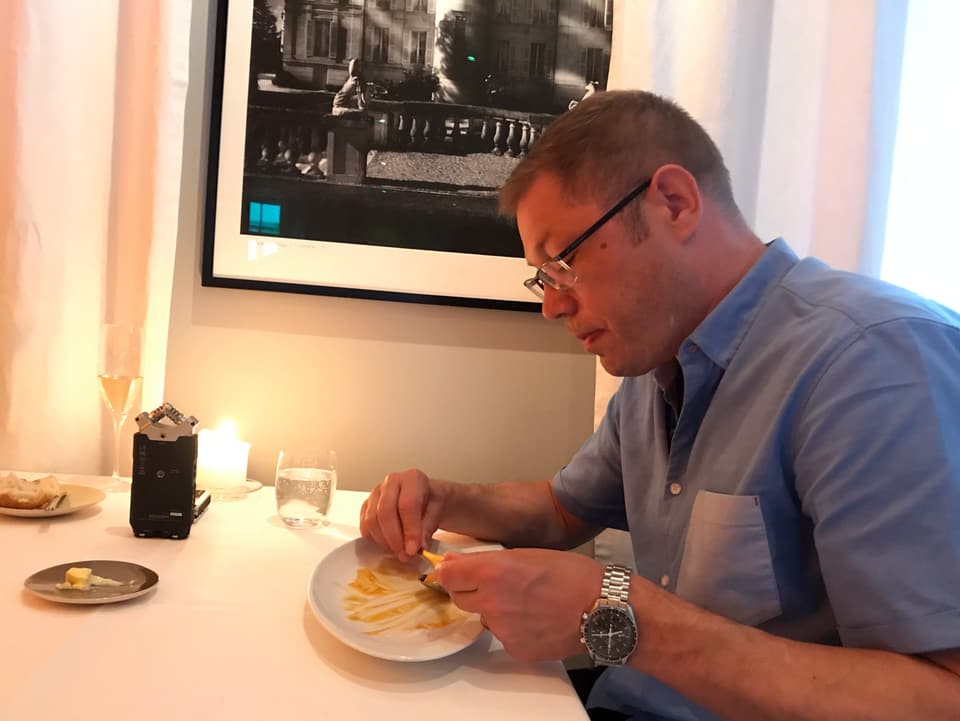 Mann sitzt vor fast leeren Teller und isst noch den Rest