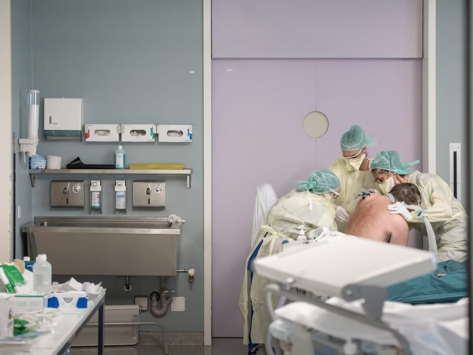 drei Ärztinnen kümmern sich um einen Patienten auf dem Spitalbett