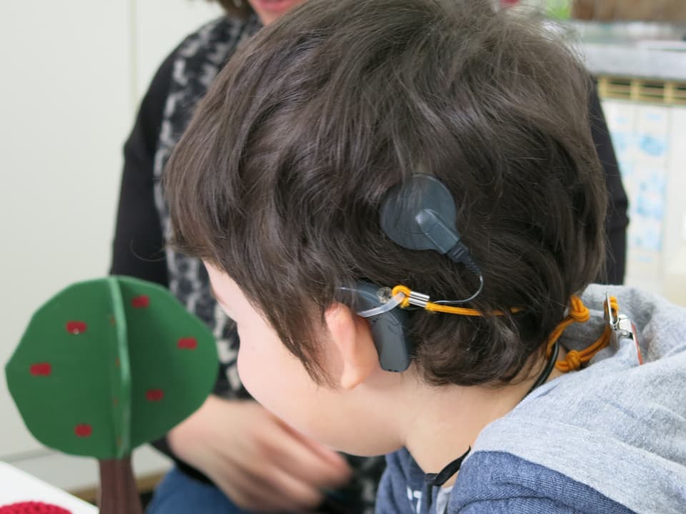 Zu sehen ist Luca Hägi mit einem Cochlea Implantat.