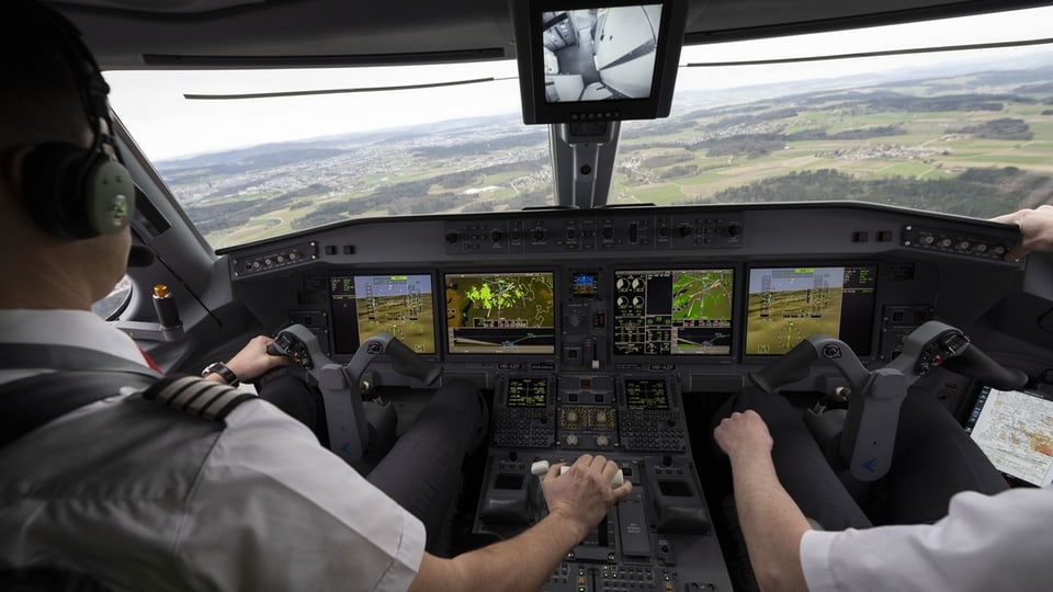 Zwei Piloten sitzen in einem Cockpit. 