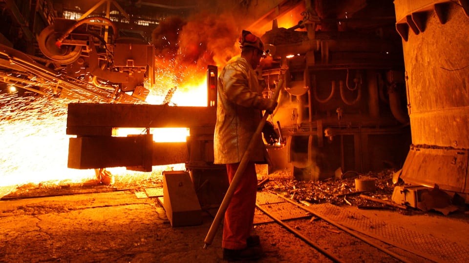 Orange Flammen und Glut bei der Stahlproduktion.