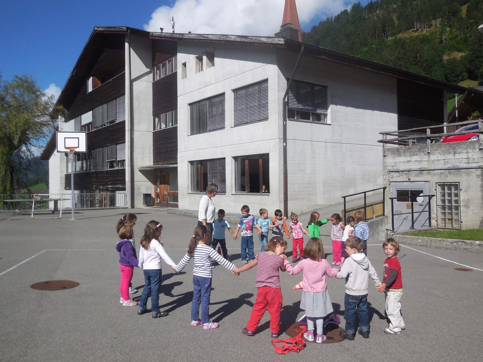 Kinder spielen auf dem Vorplatz der Schule.