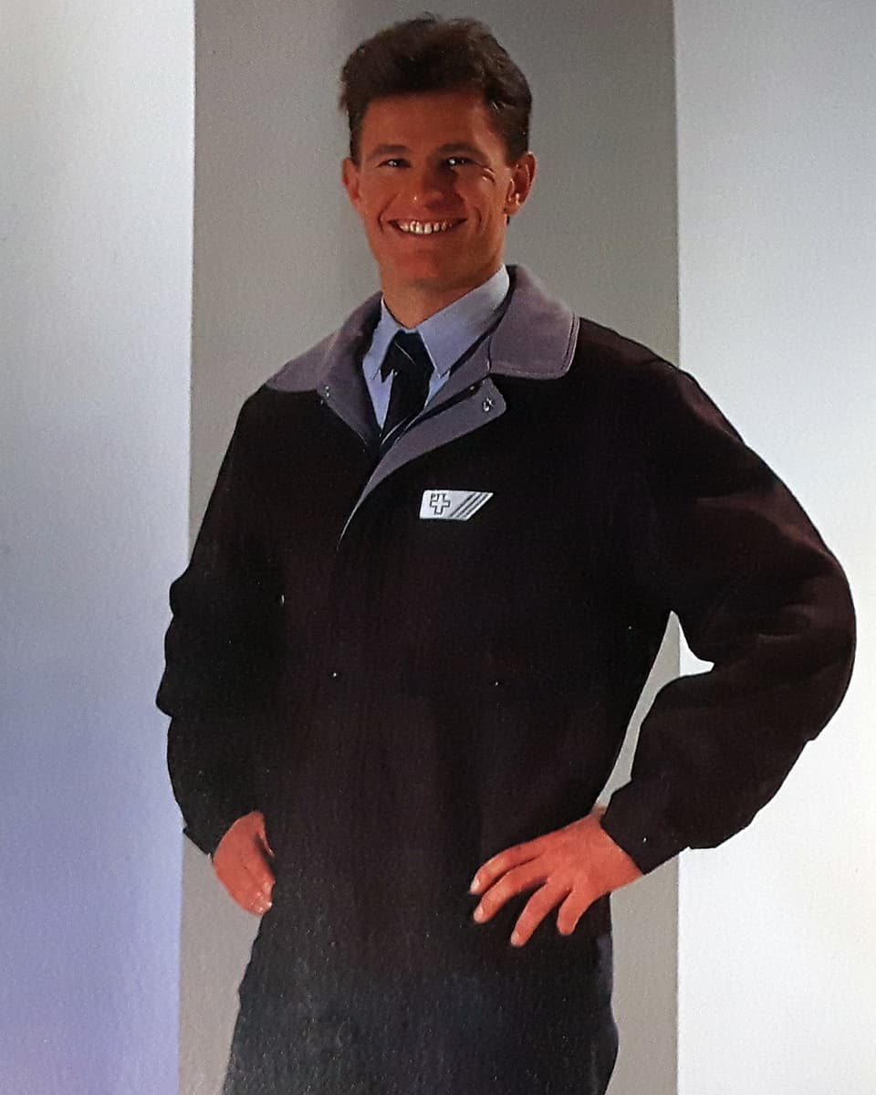 Ein Mann präsentiert strahlend eine Uniform.