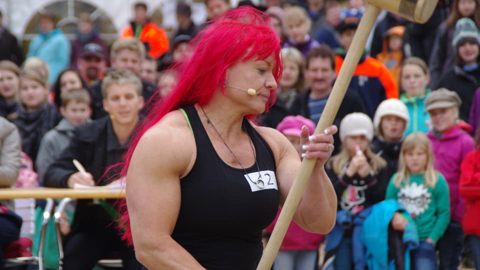Frau mit roten Haaren mit dem Hammer in der Hand