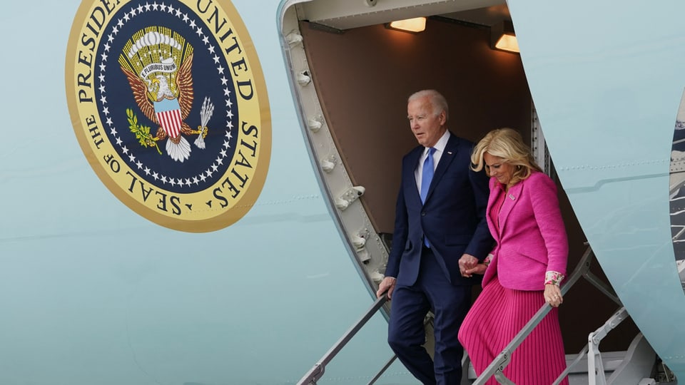 Mann in Anzug, Frau in pinkem Deux-Piece verlassen ein Flugzeug