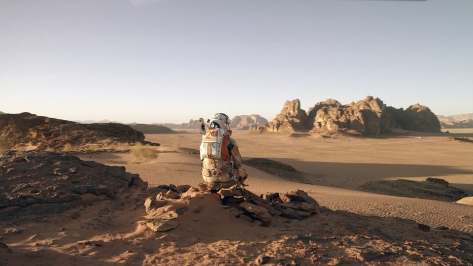 Astronaut sitzt allein in Marslandschaft