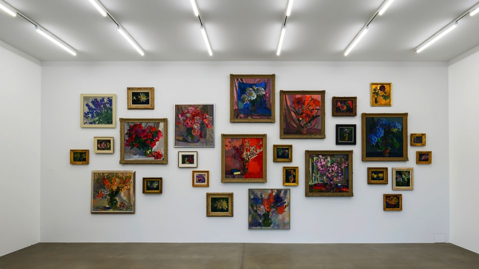 Auf dem Bild sieht man eine Wand mit vielen bunten Bildern von Augusto Giacometti.