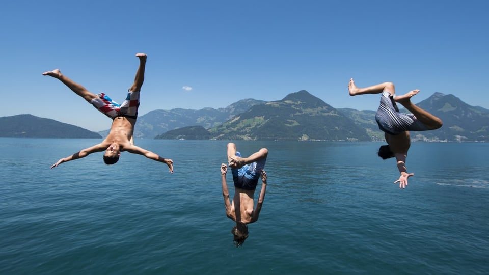 Drei Knaben springen ins Wasser. 