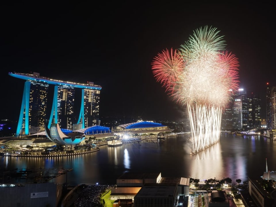 Feuerwerk steigt in einem Hafenbecken auf.