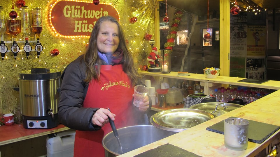 Eine Marktfahrerin schöpft Glühwein am Weihnachtsmarkt 