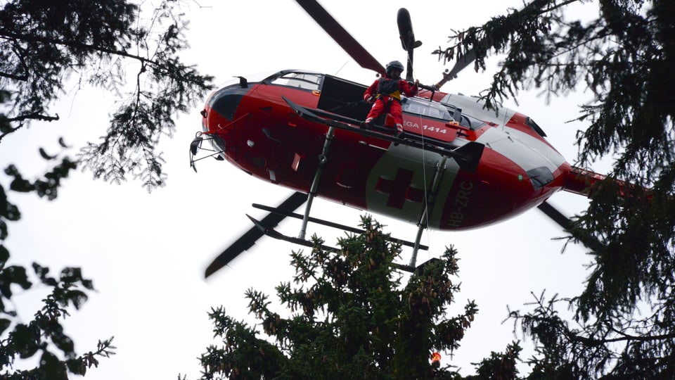 Hubschrauber mit offener Tür, Rettungssanitäter lässt Winde herunter