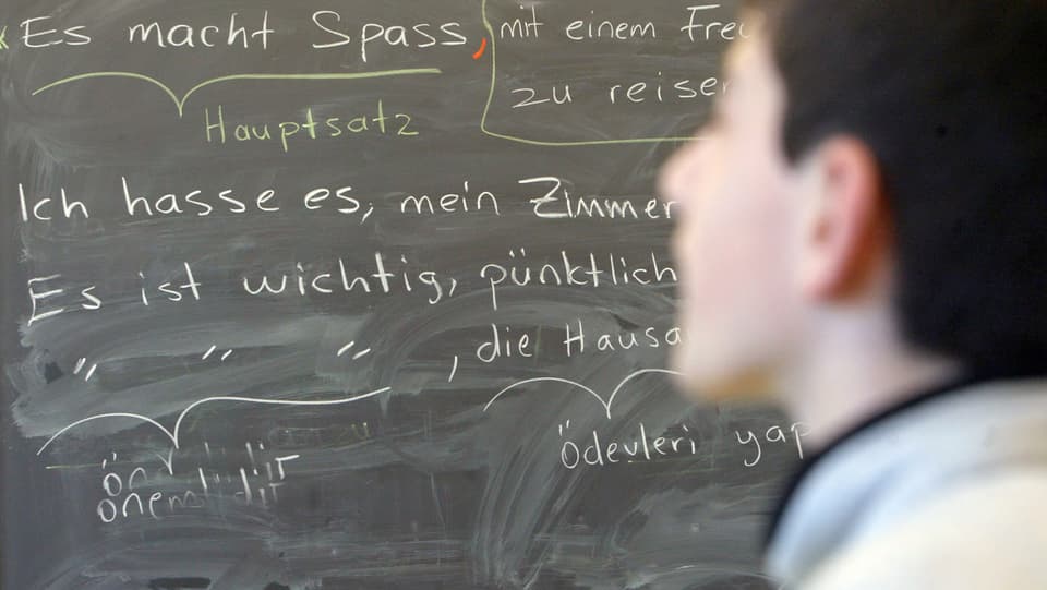 Ein Schüler vor einer Wandtafel im Deutschunterricht. 