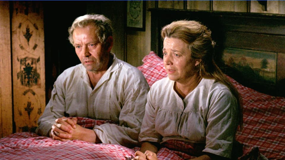 Ein Mann und eine Frau sitzen im Bett und beten.
