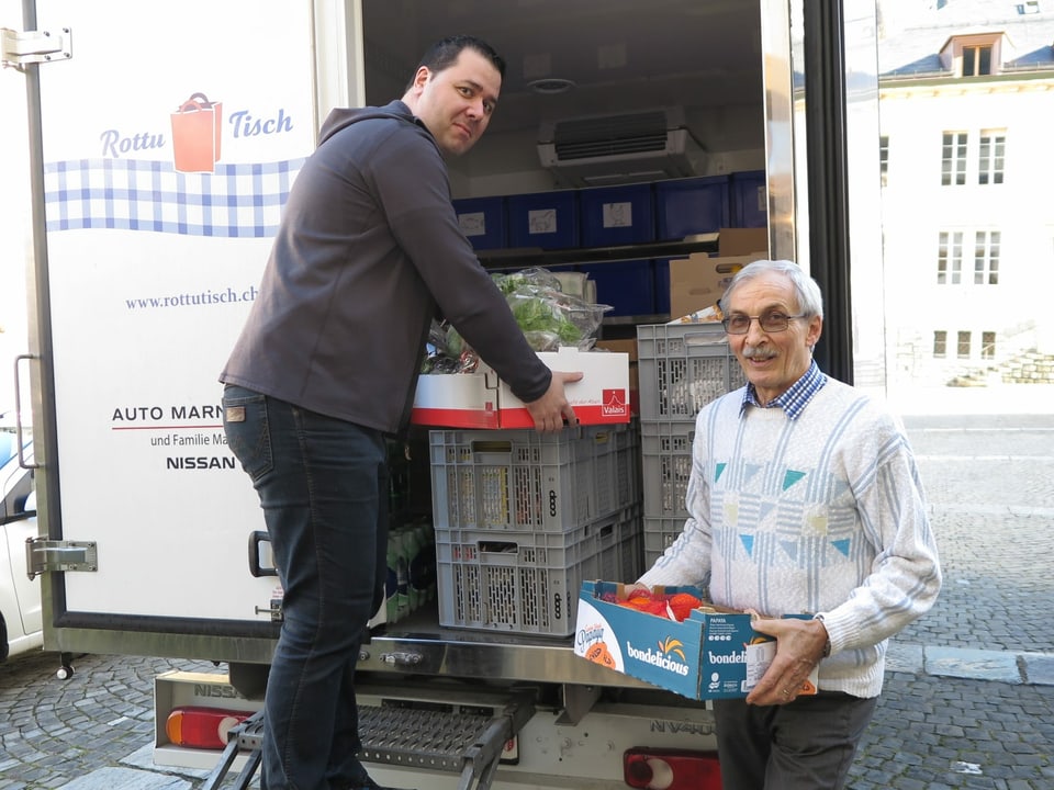 Zwei Männer laden Lebensmittel aus einem Lastwagen