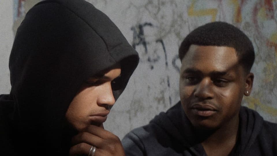 Zwei junge schwarze Männer, einer mit Hoodie.