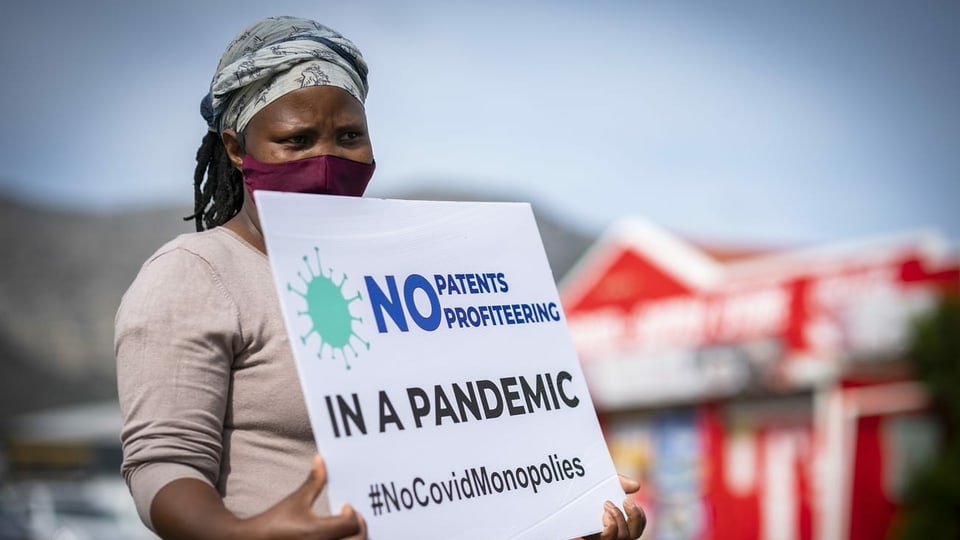 Frau mit Schild, Protest gegen Patente bei Impfstoffen