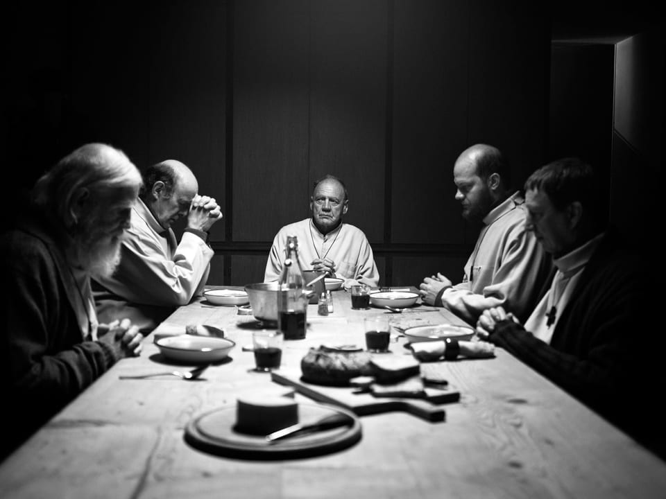 Fünf Mönche sitzen an einem Tisch