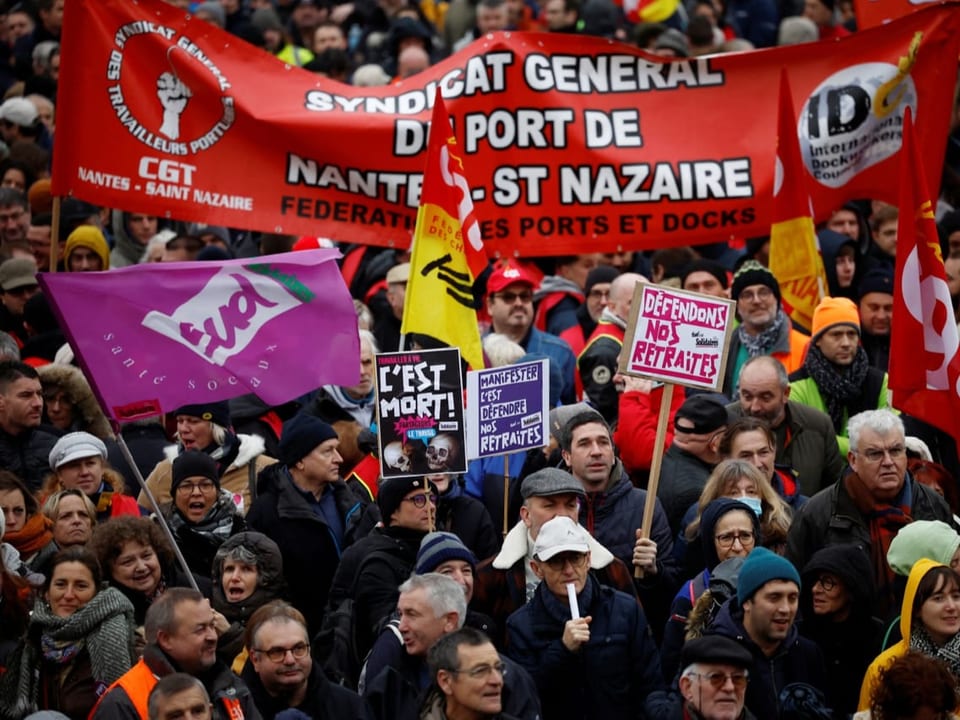 Demonstrierende protestieren mit Fahnen der französischen Gewerkschaften