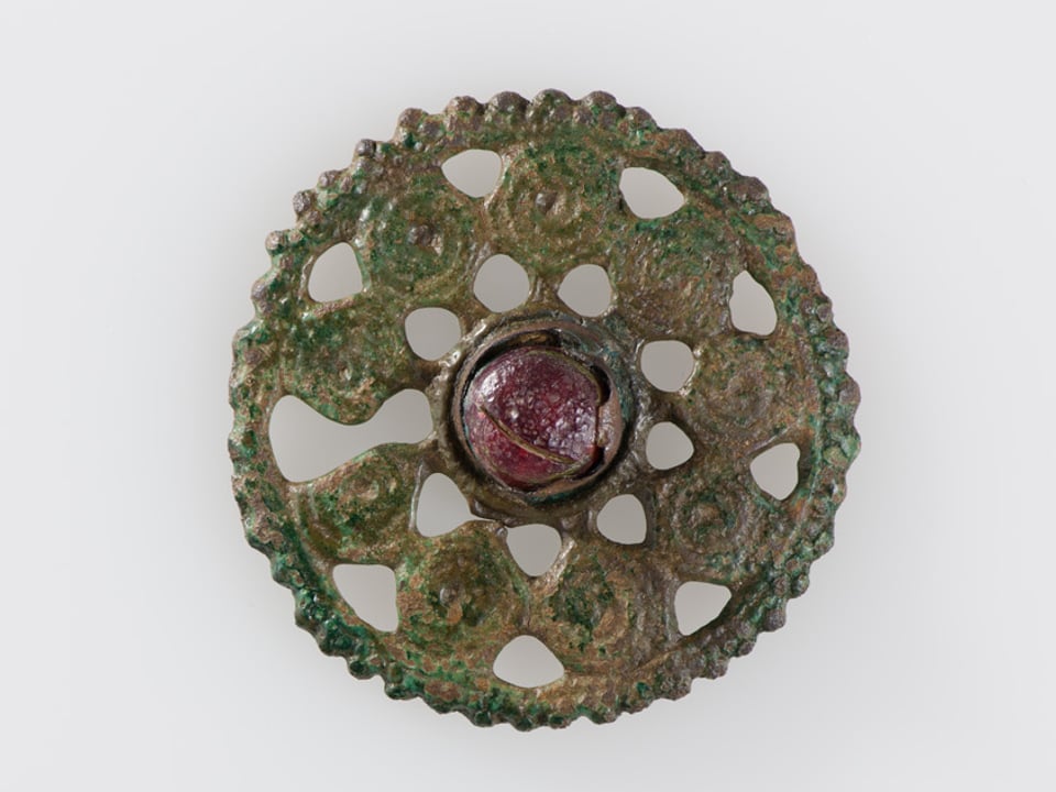 Eine Bronzefibel aus dem 9. bis 10. Jahrhundert mit einer Glaseinlage.