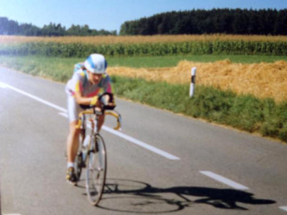 Unscharfes Bild: Eine junge Radrennfahrerin auf einer Landstrasse.