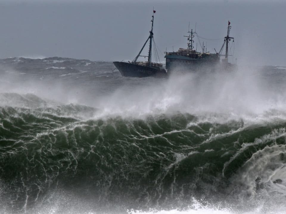Schiff umgeben von riesigen Wellen auf dem Meer.