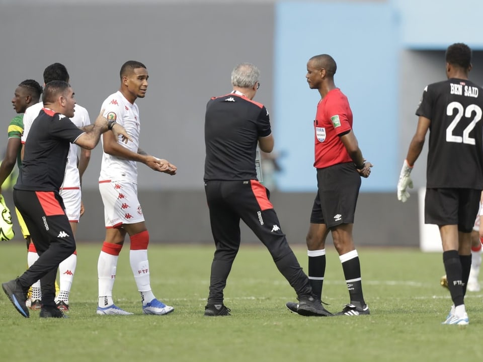 Tunesiens Trainer Mondheir Kebair deutet auf seine Uhr Janny Sikazwe.