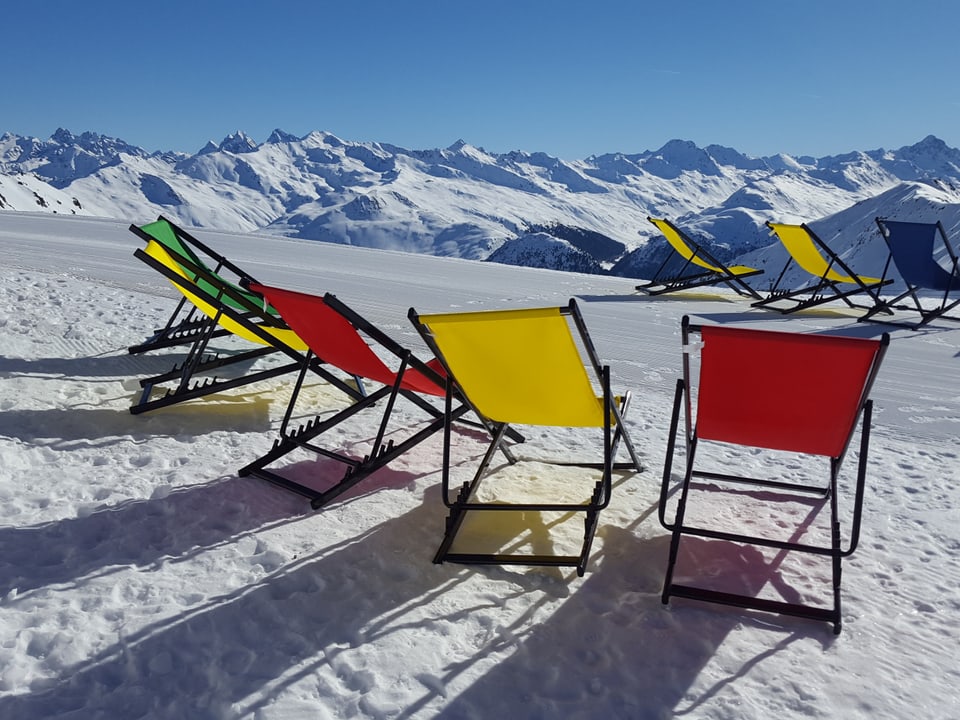 Liegestühle in den verschneiten Bergen