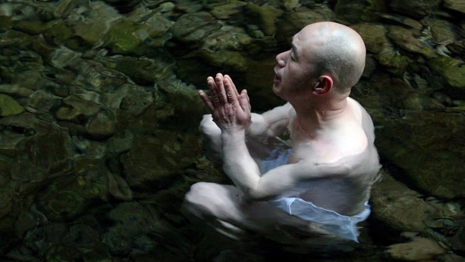 Ein Mönch meditiert im Wasser.