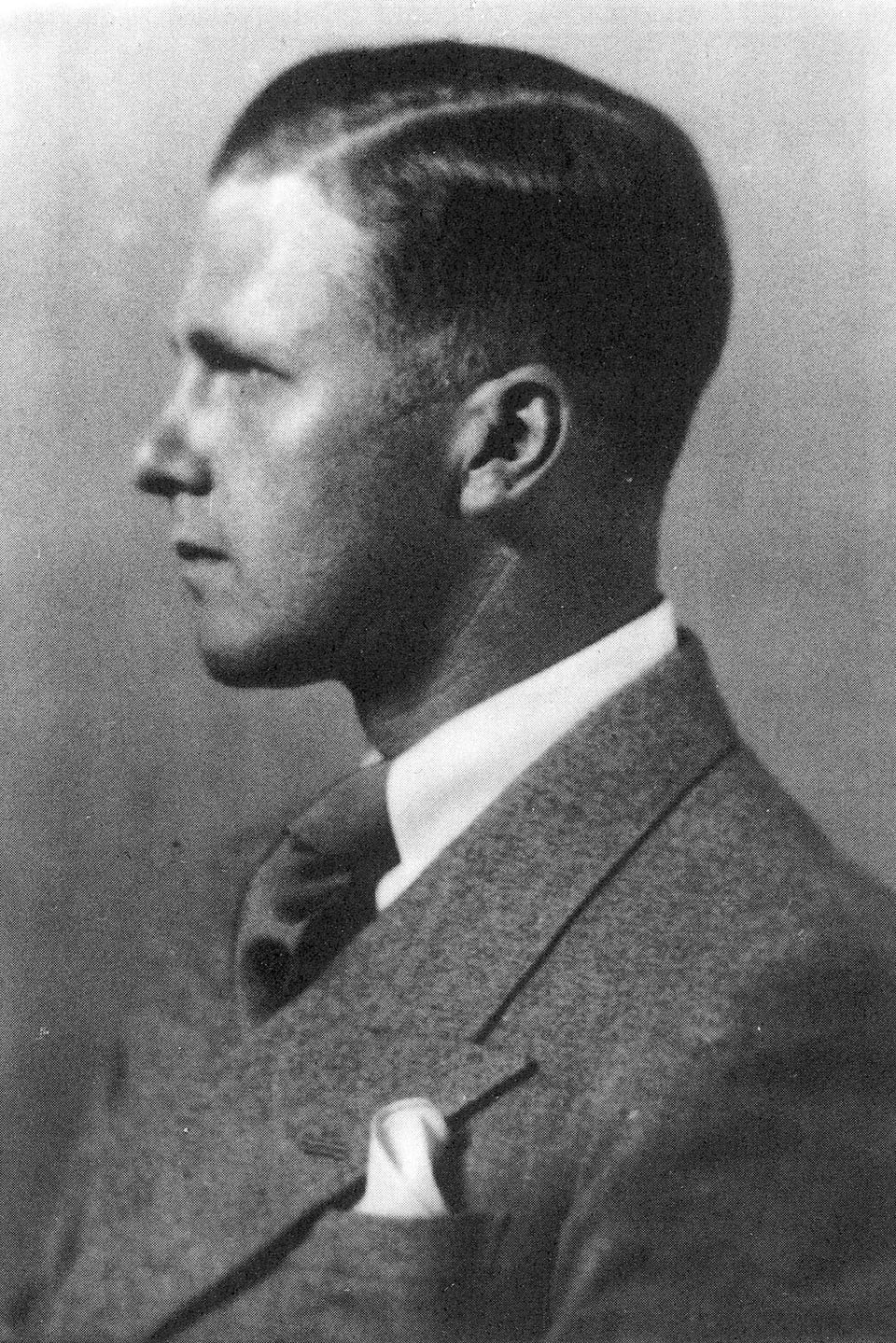 Schwarzweiss-Porträt: Seitenansicht eines jungen Mannes im Anzug.