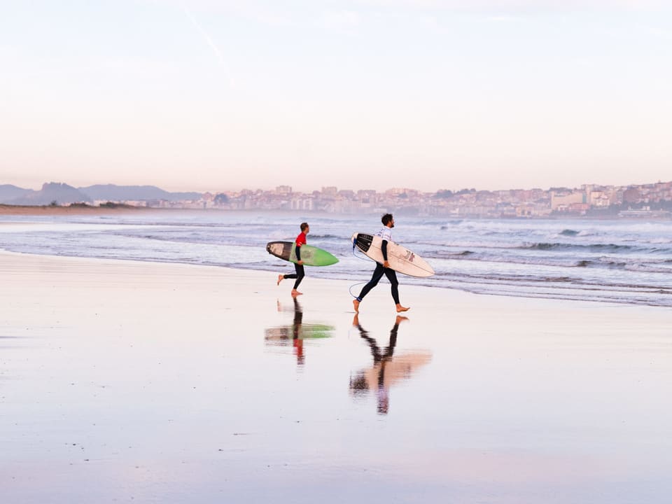 Surfer laufen ins Meer.