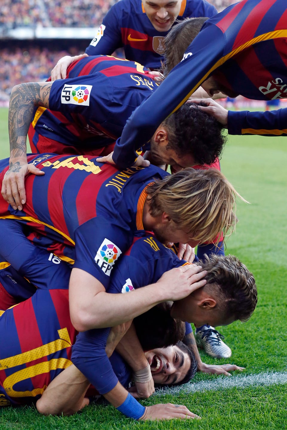 Ein Rudel von Barcelona-Spielern liegt auf Suarez