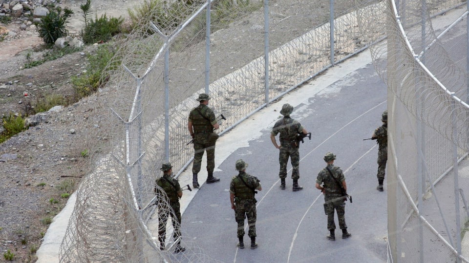 Spanische Soldaten patrouillieren am  doppelt gesicherten Grenzzaum zur Enklave Ceuta