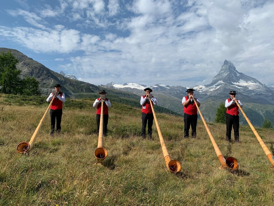 Fünf Männer spielen Alphorn vor dem Matterhorn.