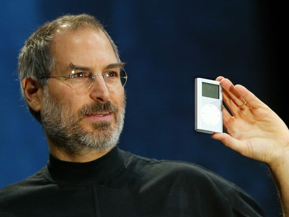 Mann in Rollkragenpullover (Steve Jobs) zeigt iPod