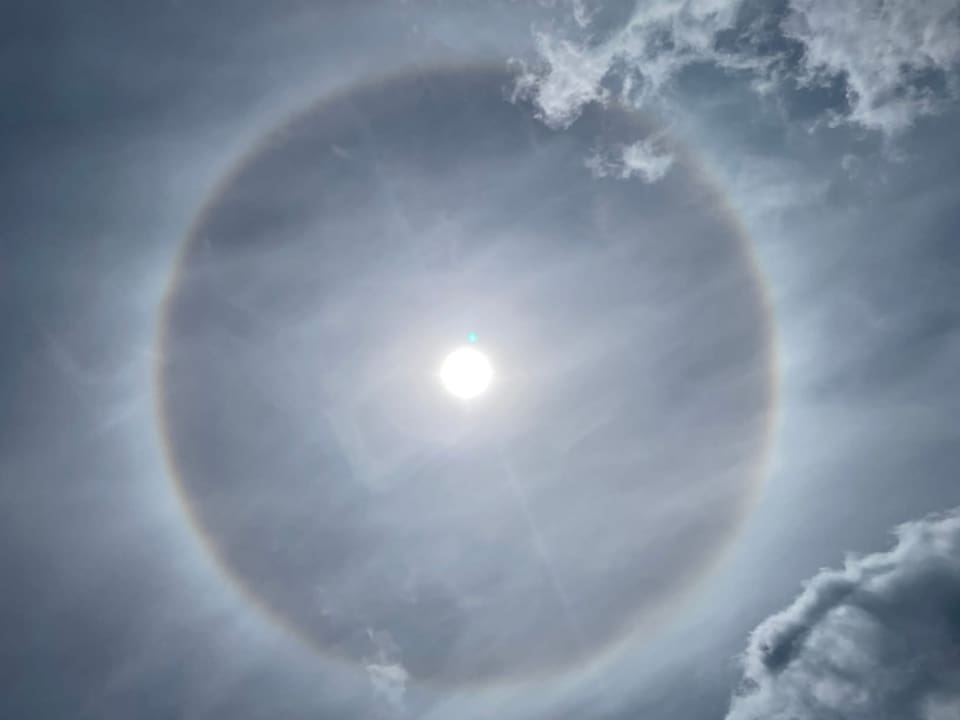 Regenbogen-Ring um die Sonne am milchigen Himmel