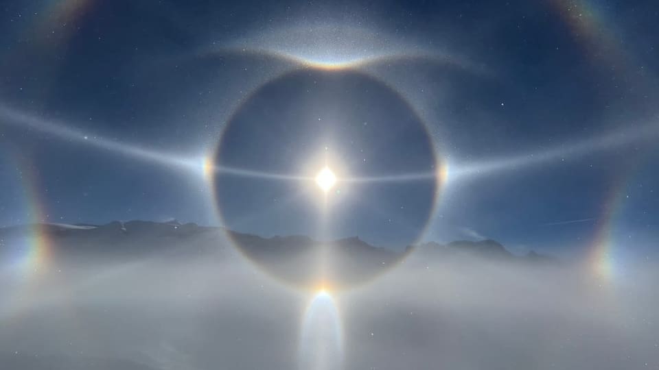 Blick über das Nebelmeer in den blauen Himmel auf die Sonne und diverse optische Erscheinungen.