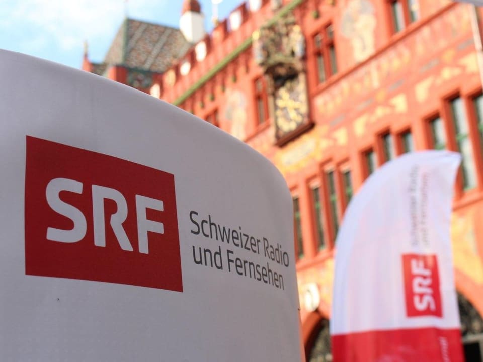 SRF Logo, im Hintergrund das Rathaus